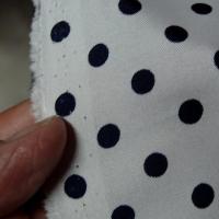 Polyester fin satine blanc pois noirs 
